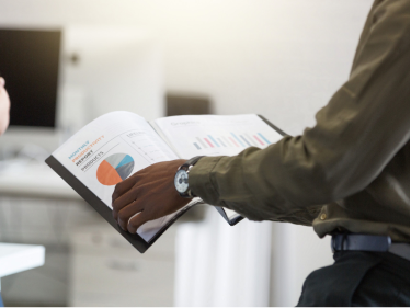 Business professional reviewing a financial report with charts and graphs